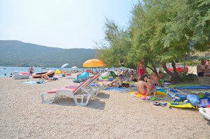 A crowded beach with people sunbathing and swimming. - Apartments Oliva (Sibenik)