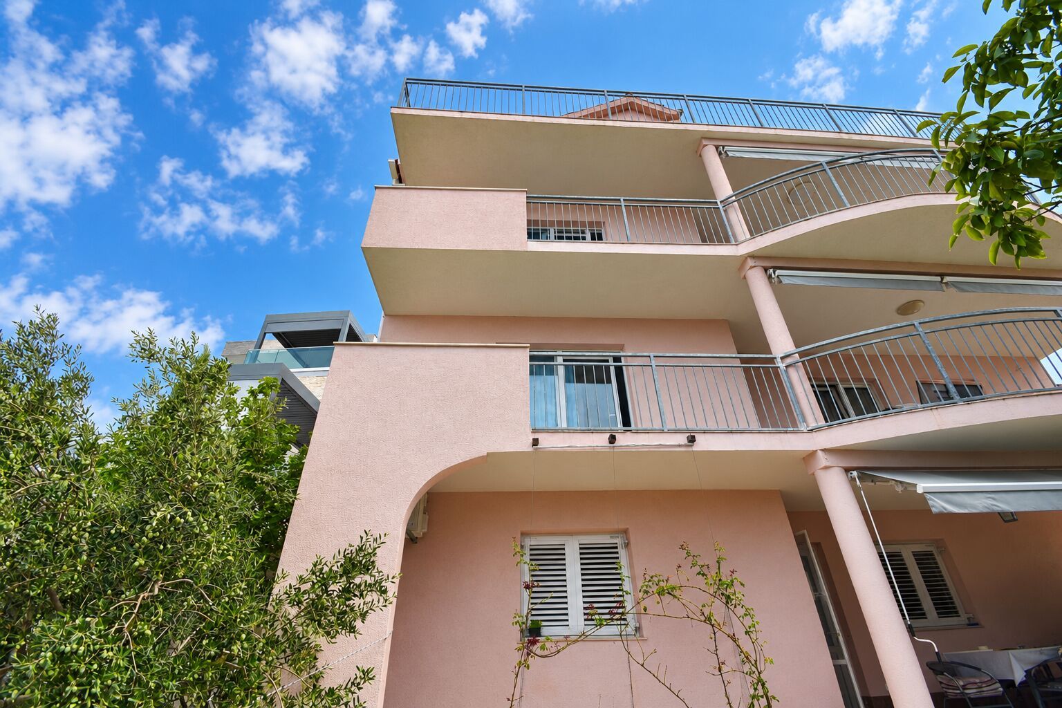 A multi-story building with balconies and a clear sky.