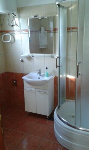 Ein Badezimmer mit Waschbecken, Spiegel und Dusche.