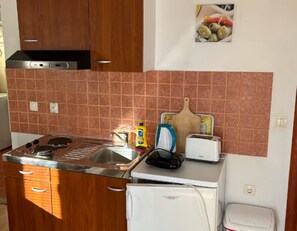 Eine kleine Küche mit Herd, Spüle und Toaster.