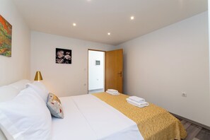 A hotel room with a bed, a bedside lamp, a door, and a towel on the bed. - House Adora (Benkovac)