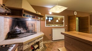 Una cucina con camino integrato, un piano di lavoro in legno e un lampadario.