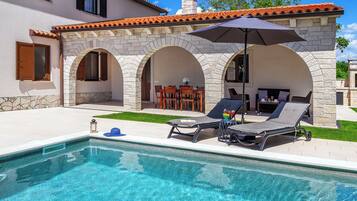 Piscine extérieure, parasols de plage, chaises longues