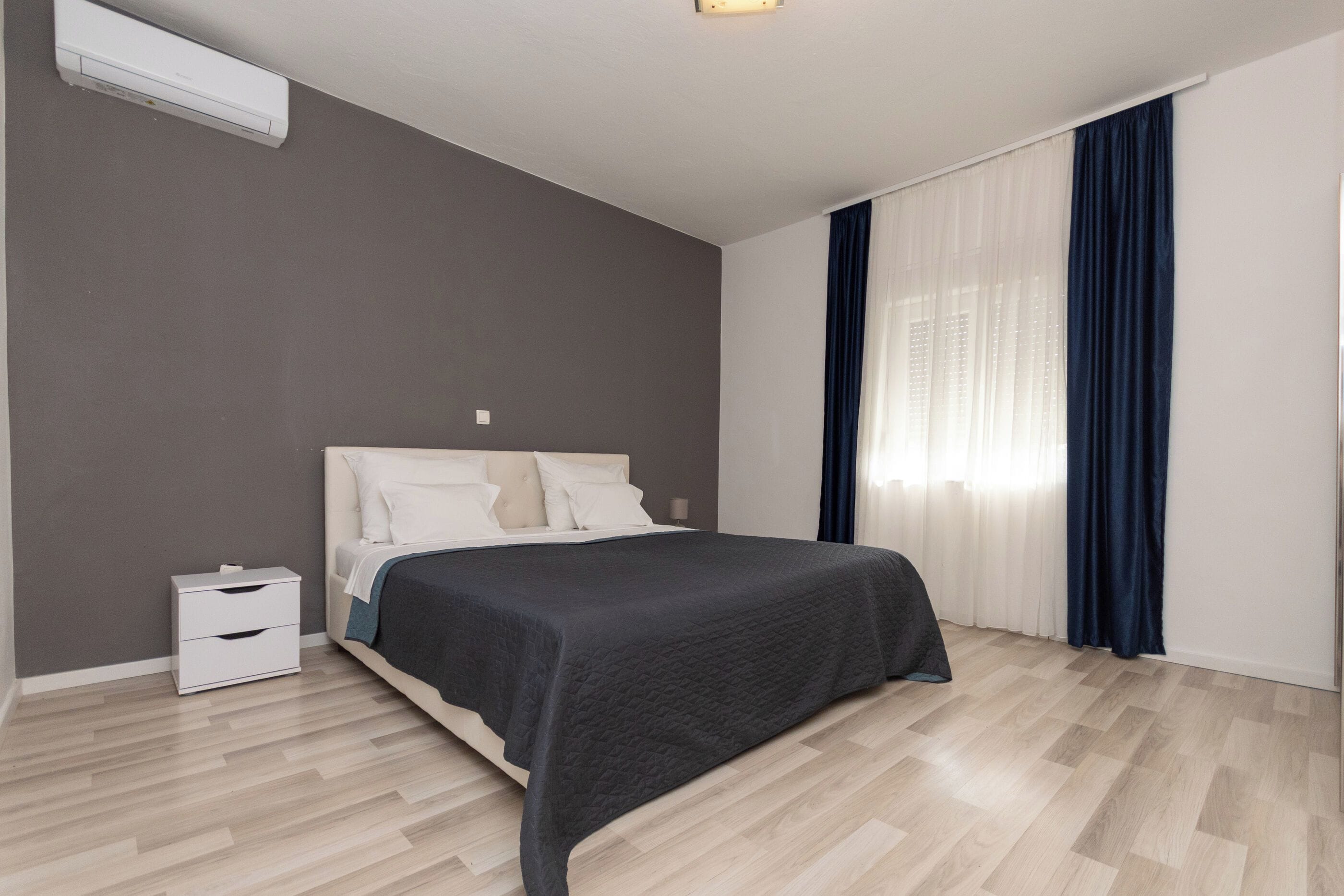 Ein modernes Schlafzimmer mit einem Bett, Nachttischen und einem Beistelltisch.