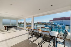 Ein großzügiger Außenbereich mit Billardtisch, Pool und Sitzgelegenheiten.