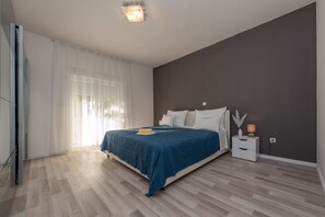 Ein Schlafzimmer mit Bett, Nachttisch und einem fenster mit Vorhängen.