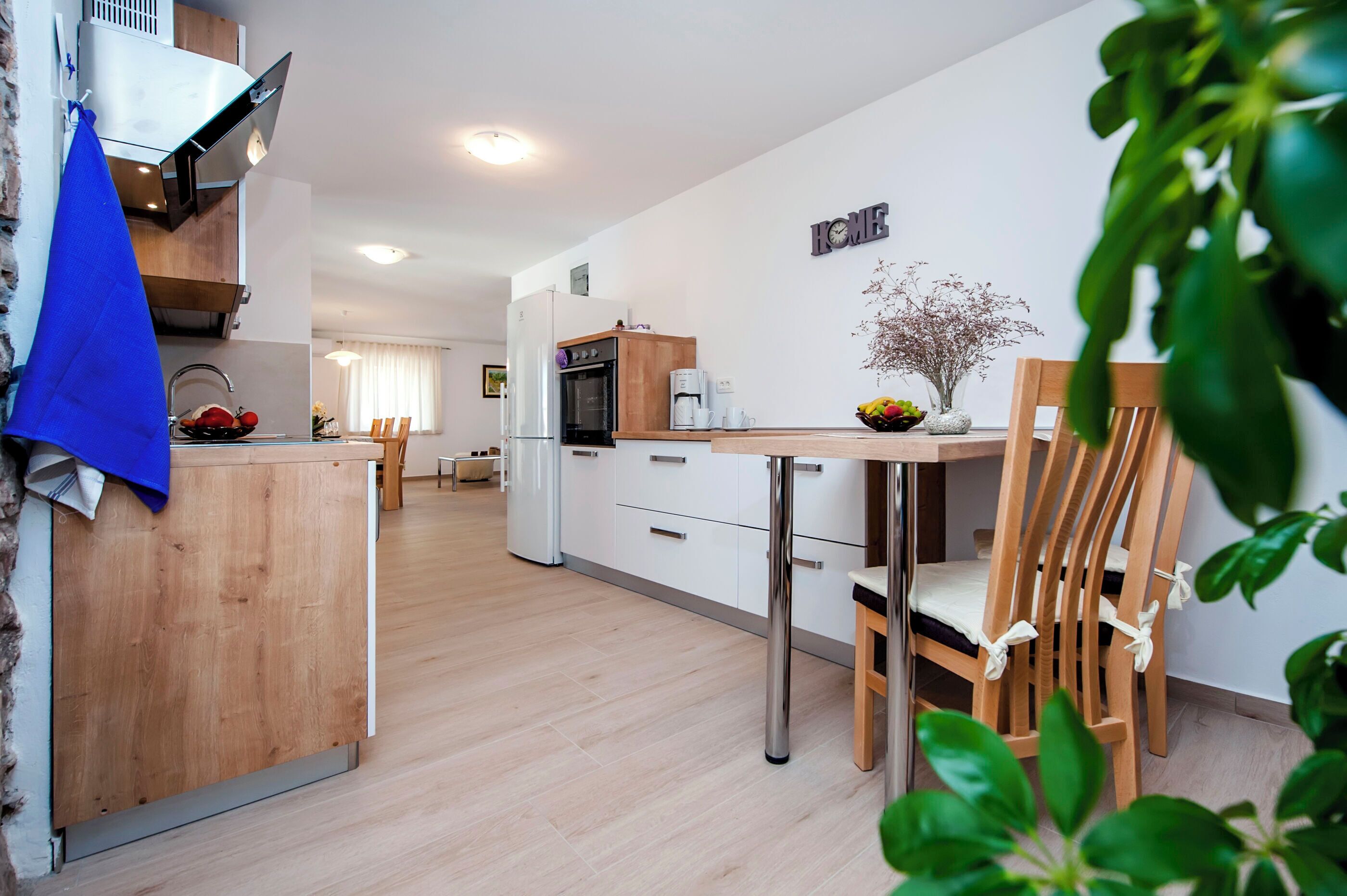 Une cuisine moderne avec un îlot central, des chaises en bois et une table à manger.