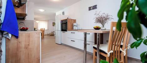 Une cuisine moderne avec un îlot central, des chaises en bois et une table à manger.