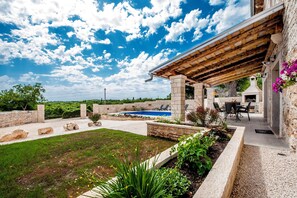 A pool area with a pergola, stone walls, and outdoor seating. - Villa Masi (Kanfanar)