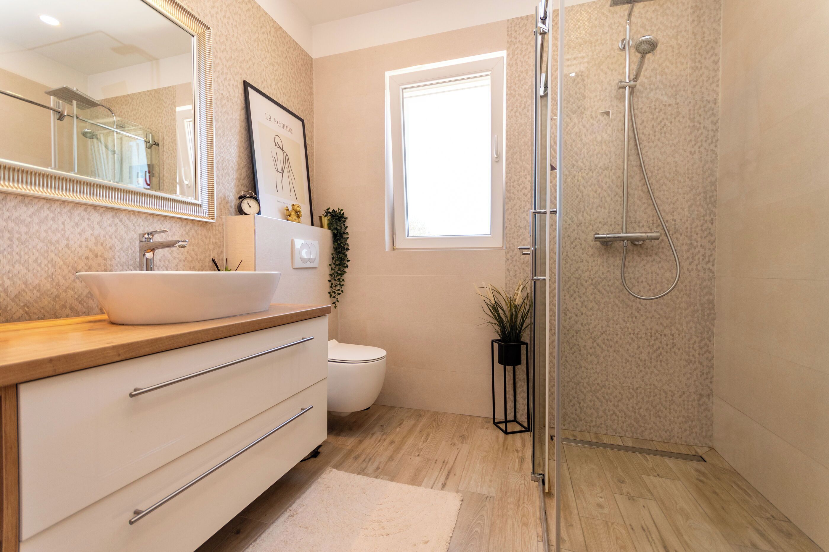 Un baño moderno con un espejo grande, un lavabo, un inodoro y una ducha.