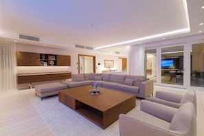 Una sala moderna con un sofá seccional, una mesita de centro y un mueble empotrado para entretenimiento.