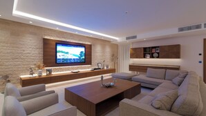 A modern living room with a flat-screen TV, a wooden coffee table, and a sectional sofa. - Villa Lusso Mare Istria (Umag)