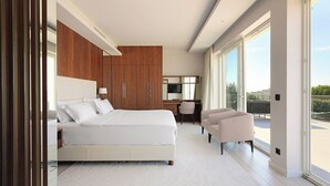 A modern hotel room with a large bed, a desk, a chair, and a balcony with a view. - Villa Lusso Mare Istria (Umag)