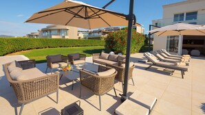 An outdoor patio with wicker furniture, a table, and umbrellas. - Villa Lusso Mare Istria (Umag)