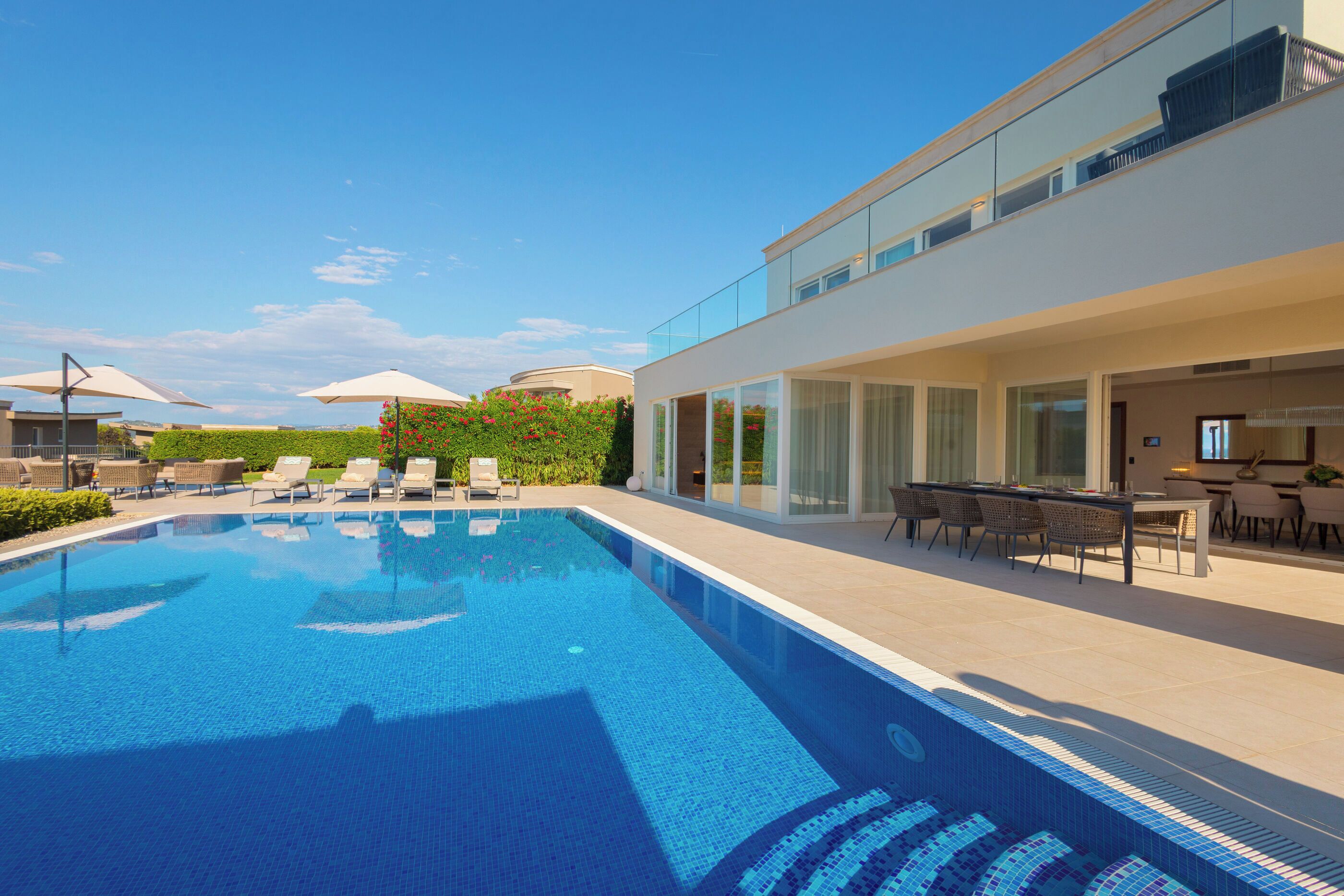 Una piscina al aire libre, una piscina infinita, sombrillas