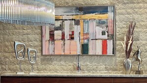 A modern dining area with a marble table, six grey upholstered chairs, a large abstract painting, and a decorative metal sculpture. - Villa Lusso Mare Istria (Umag)