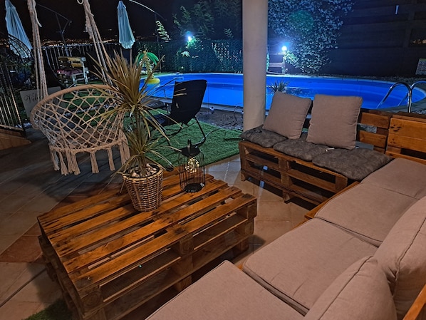 A cozy outdoor seating area with a wooden bench, a wicker chair, and a cushioned sofa. - Villa Emily (Opatija)