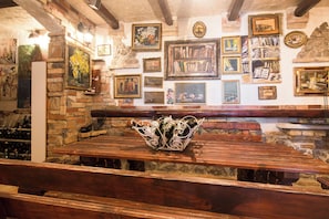 A bar area with wooden benches and a wine rack. - Villa Emily (Opatija)