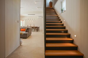 Eine Treppe führt zu einem Essbereich mit einer Couch und einem Tisch.