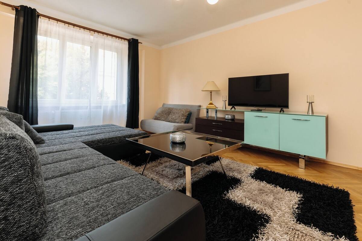 A modern living room with a sofa, a coffee table, a TV, and a cabinet.
