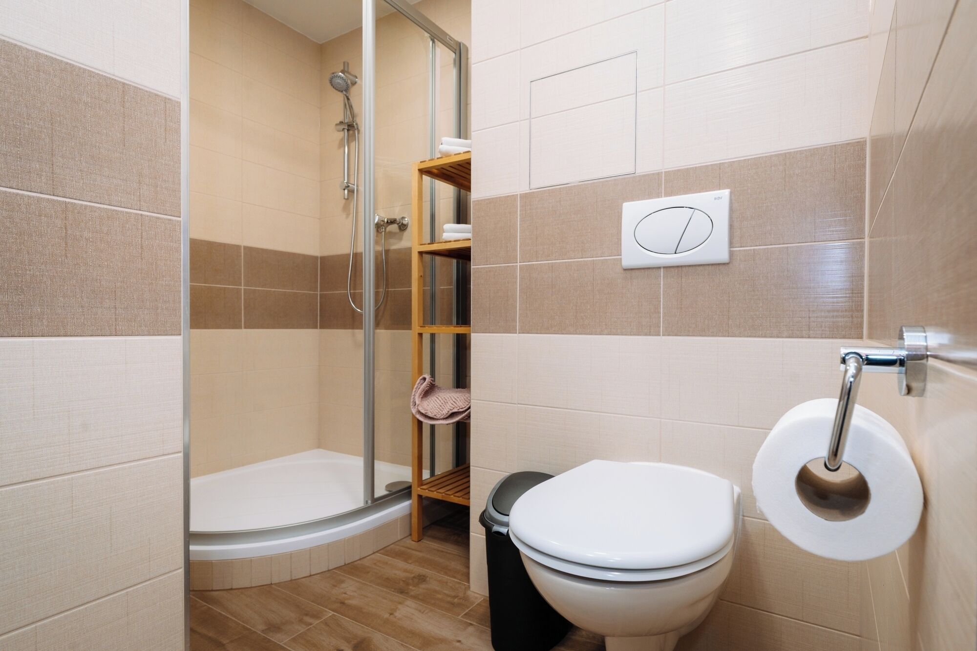 Une salle de bain avec une douche, des toilettes et un porte-serviettes.