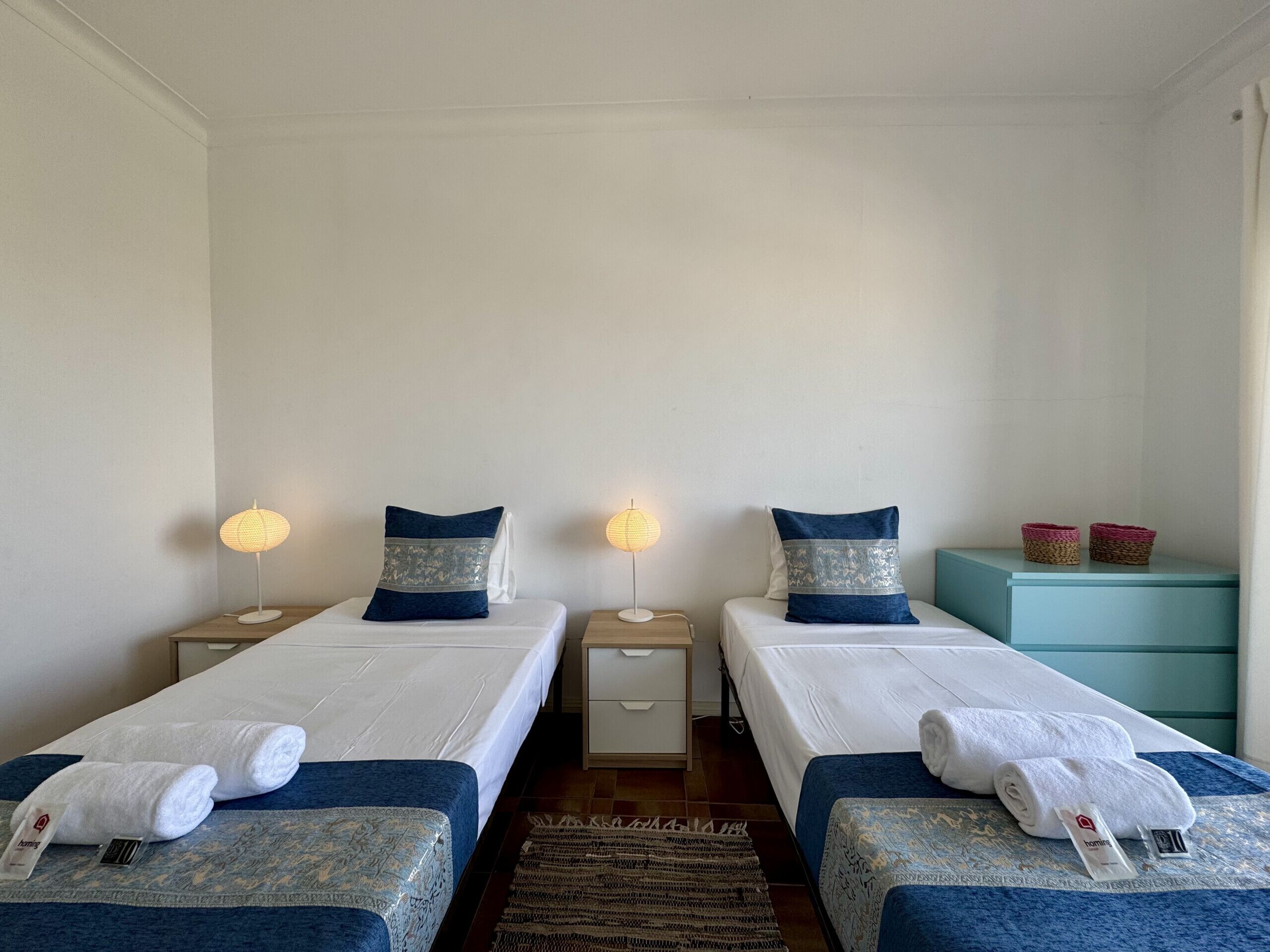 Une chambre double avec deux lits, des lampes de chevet, une petite table et une table de nuit.
