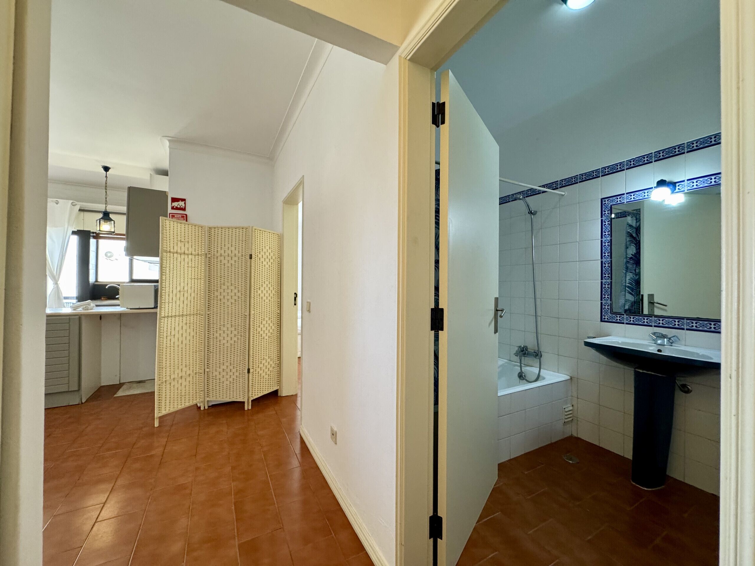 A bathroom with a shower, a sink, and a mirror.