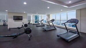 A gym with treadmills, stationary bikes, and a rowing machine. - Luxury Holiday Home | Spacious & Fully Furnished (Dubai)