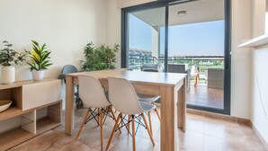Un'area pranzo moderna con un tavolo in legno, sedie e piante in vaso.