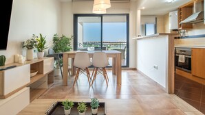 Una cucina moderna con zona pranzo, ampie finestre e vista sulla città.