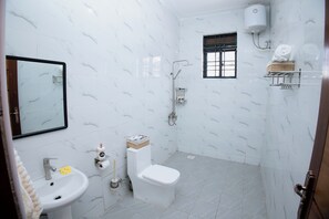 Een douche, handdoeken, zeep, toiletpapier