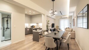 Una cocina moderna con comedor, cabina de ducha de vidrio y un ventanal amplio.