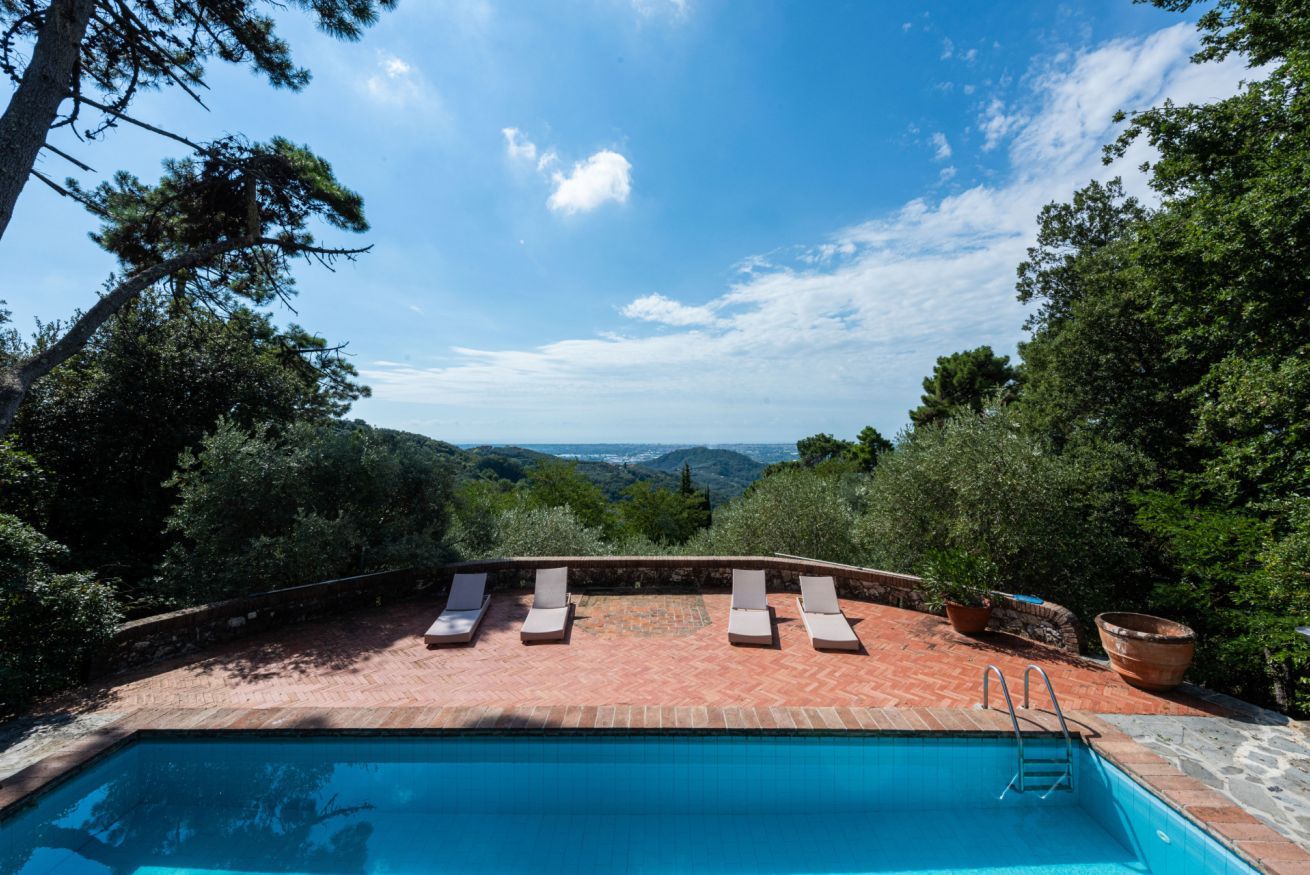 A swimming pool with lounge chairs and a view of the landscape.