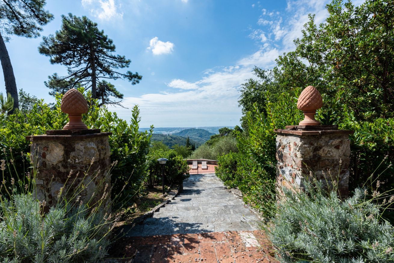 A stone pathway leading to a building with a view of the landscape.