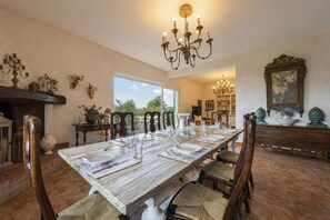 A dining room with a long table set for six, surrounded by wooden chairs. - Villa la Leccia by MMega (Massarosa)