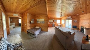 Ein Blockhaus-Interieur mit Schlafzimmer, Wohnbereich und Küchenzeile.