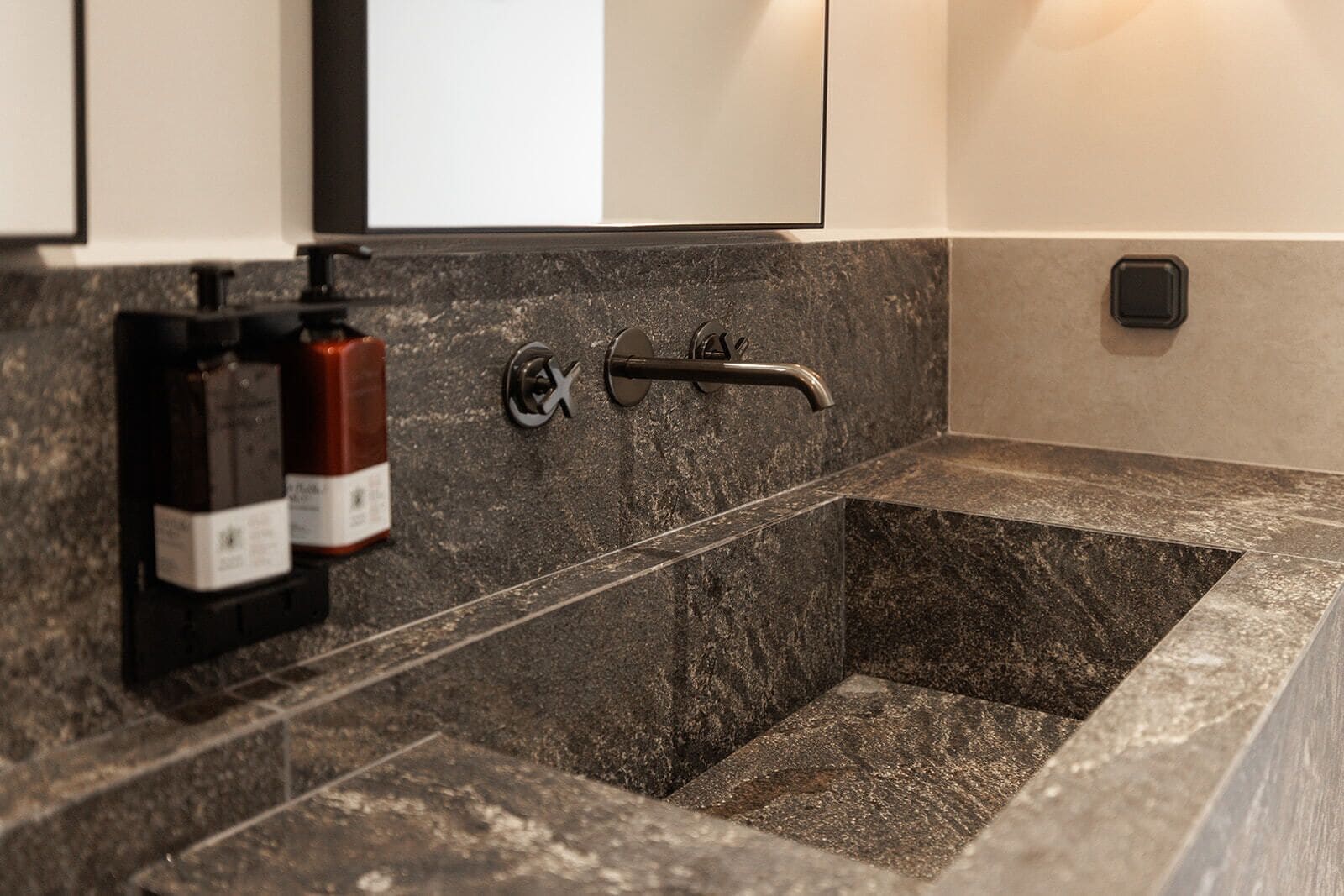 Ein Badezimmer mit Marmorwaschbecken, Handtuchhalter und zwei Seifenspendern.