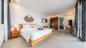 Un dormitorio con cama de madera, mesitas de noche, un espejo, un ventilador de pared y vistas al baño.
