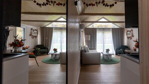 Una sala de estar moderna con un sofá, sillas, una mesa de comedor y una zona de cocina.