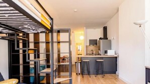 Eine moderne Wohnung mit Küche, Essbereich und Wohnzimmer mit Sofa.