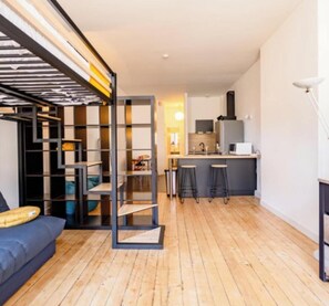 Eine moderne Wohnung mit Küche, Essbereich und Wohnzimmer mit Sofa.
