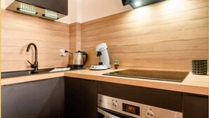 Eine moderne Küche mit Einbauofen, Kaffeemaschine und Wasserkocher.