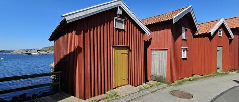 A red wooden building with a yellow door, a small window, and a door with a handle.