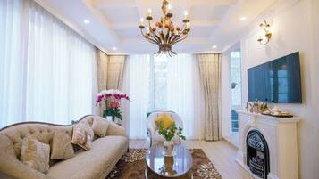 Deluxe Villa | Living area | 65-inch Smart TV with cable channels