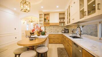 A modern kitchen with a round island, wooden cabinets, and a marble backsplash.