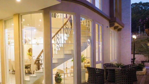 Une maison moderne dotée d’une piscine, d’un escalier et de meubles en osier.
