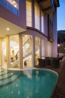 Uma casa moderna com piscina, escadas e móveis de vime.