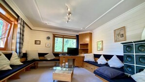 En hyggelig stue med sofa, sofabord, fjernsyn og bogreol.