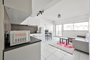 Een modern appartement met keuken, eethoek en woonkamer.