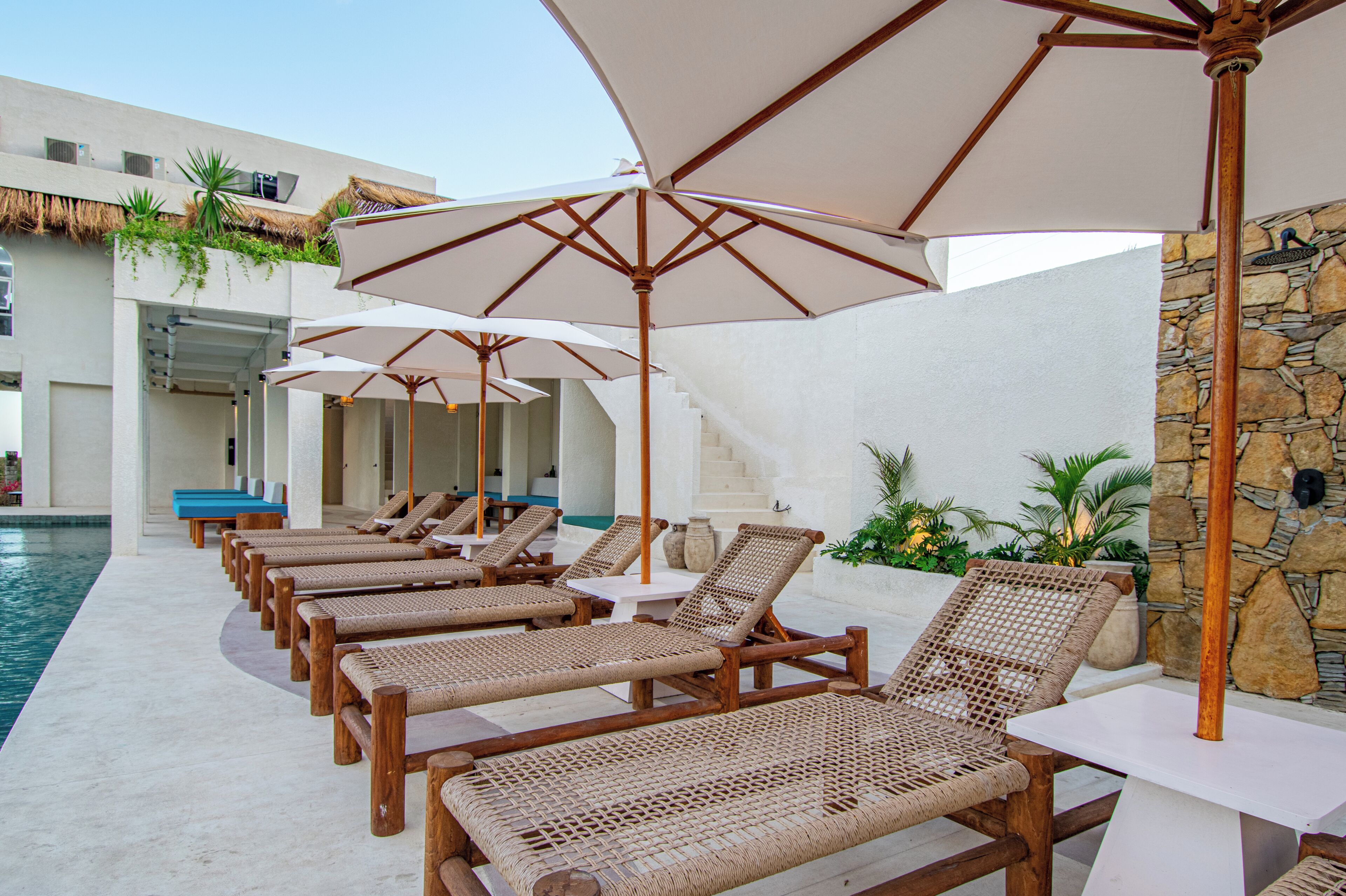A poolside area with lounge chairs and umbrellas.